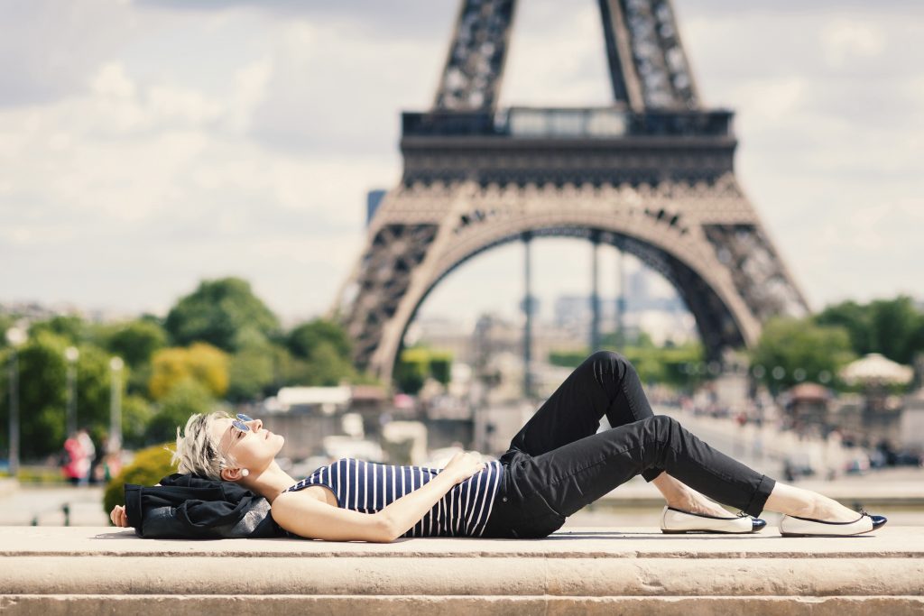 Relaxed young blonde woman portrait laying on the ground.