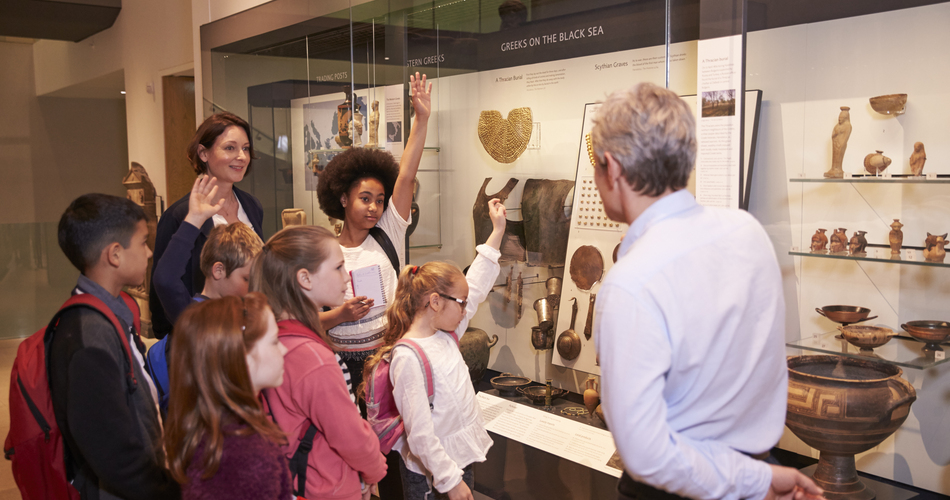 Students,Looking,At,Artifacts,In,Case,On,Trip,To,Museum