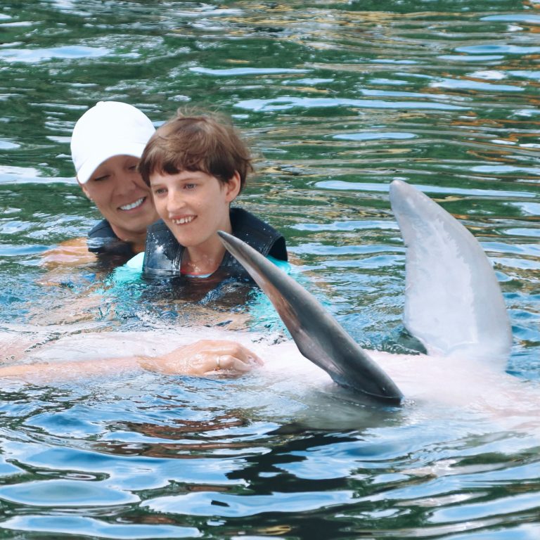 Island Dolphin Care child swimming with dolphin. Photo credit Island Dolphin Care Facebook 768x768
