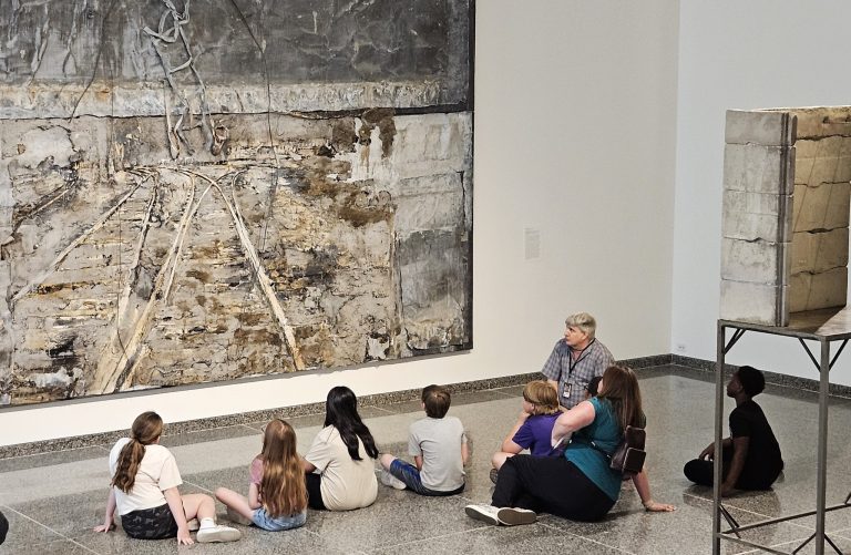 Des Moines Art Center examining art with staff. Photo credit Des Moines Art Center Facebook 768x501