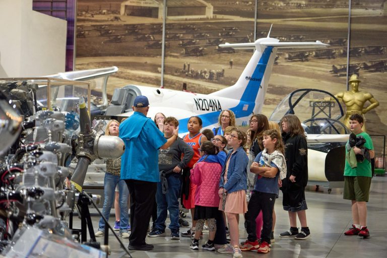 Tulsa Air and Space Museum TASM museum docent volunteer leading a student tour. Photo credit Tulsa Air and Space Museum TASM Facebook 768x512