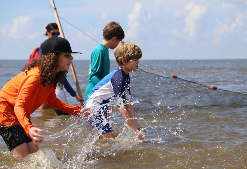 Middle schoolers pulling a seine net in shallow water along the Alabama Gulf Coast. Photo credit - Gulf Coast Research Laboratory Facebook